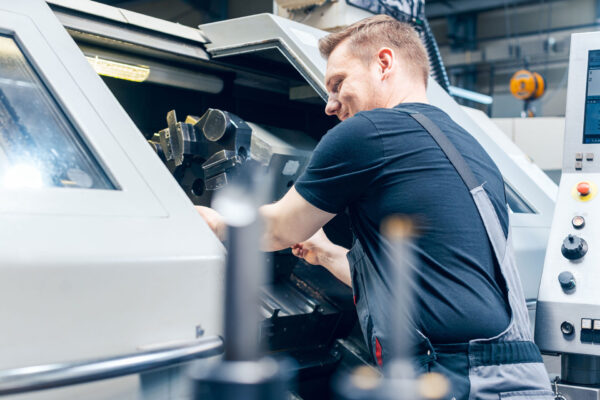 Maschinenbau – Experienced-worker-changing-tool-setup-of-lathe-machine Maschinenbau - Experienced-worker-changing-tool-setup-of-lathe-machine