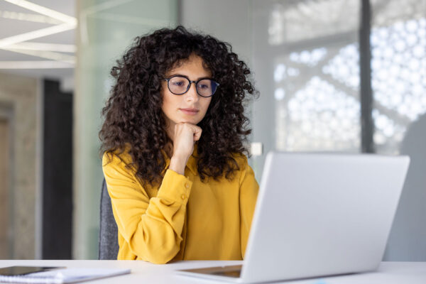 Geschäftsfrau prüft digitale Rechnung mit SAP Business One auf Laptop