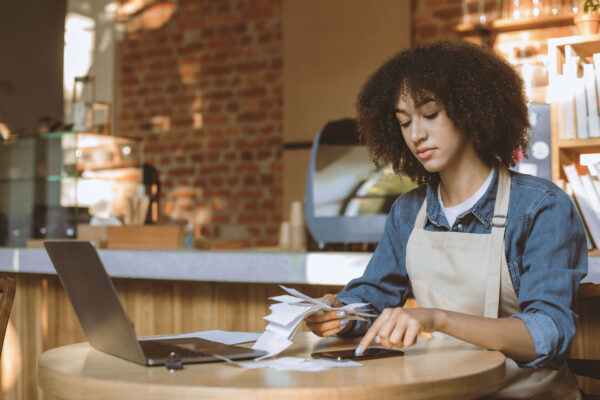Frau in Cafe prüft Finanzen und Belege mit SAP Business One