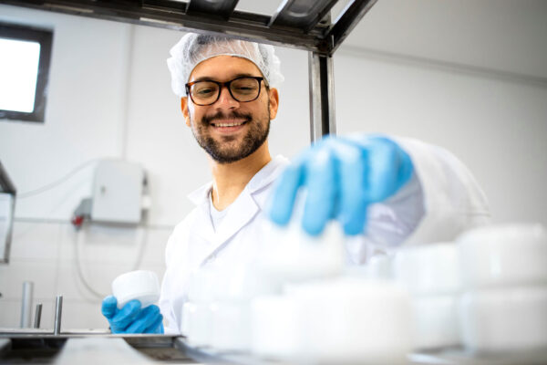 Pharma-Close-up-view-of-pharmaceutical-worker-technologist-working-in-cosmetics-factory-with-healthcare-creme-products.
