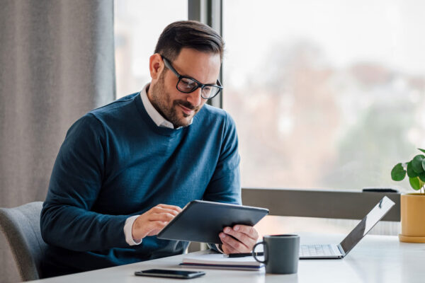 Young-businessman-using-digital-tablet-while-working-in-business-office.